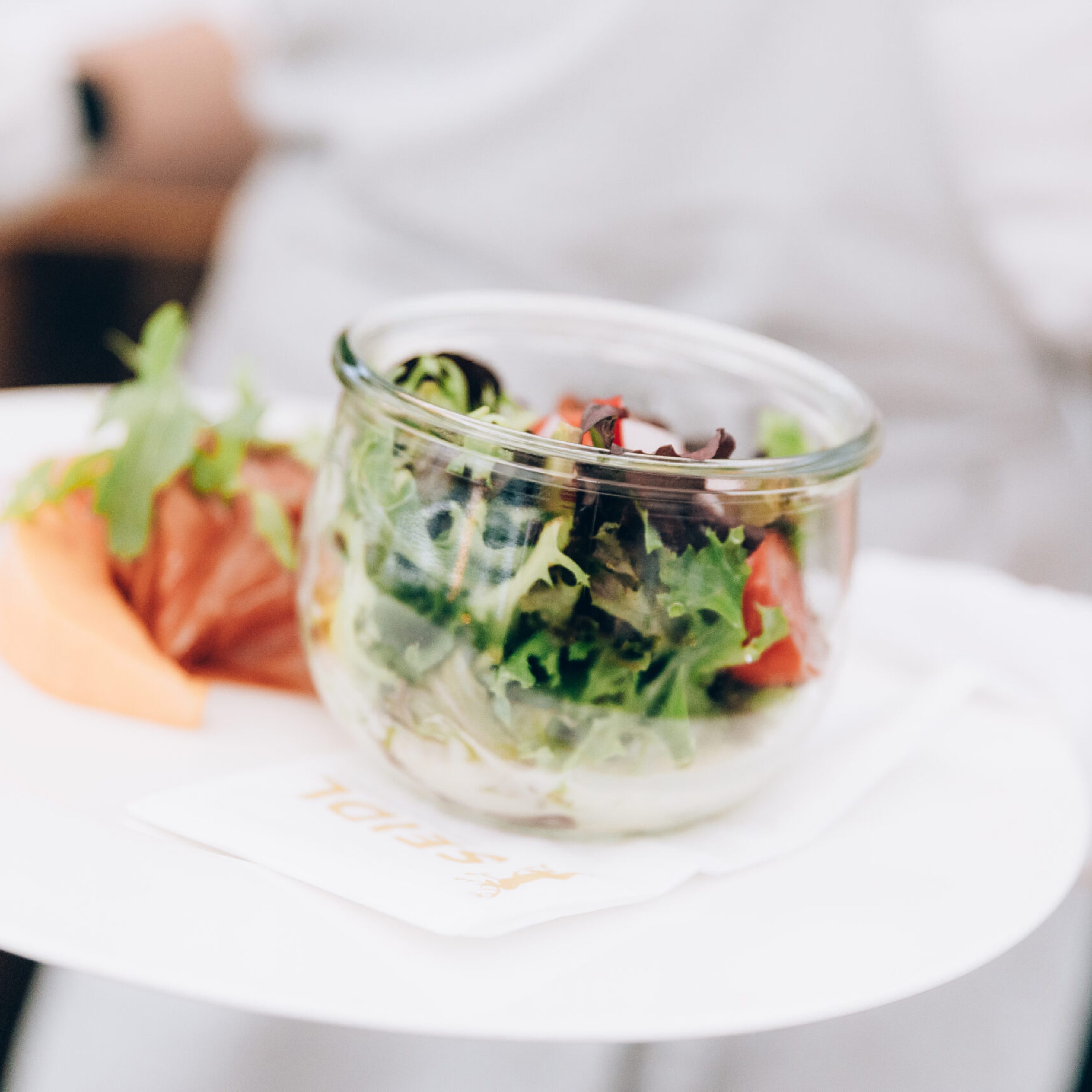 Serving plates with green salad in restaurant.